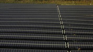 Aerial view of solar panels on field with town in distance video