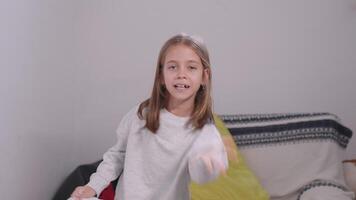Mischievous girl tearing paper and throwing it up in air at home video