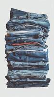 Pile of denim blue jeans stack isolated on white background photo