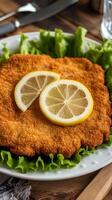 A piece of fried chicken with a lemon wedge on top photo