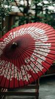An open red umbrella with white flowers photo