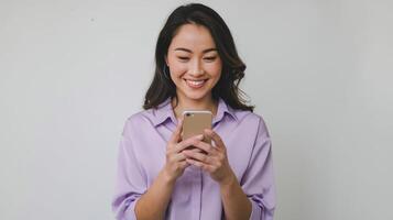 Asian woman smiling while using her phone photo