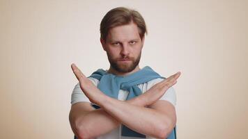 Young man say No hold palm folded crossed hands in stop gesture warning of finish prohibited access video