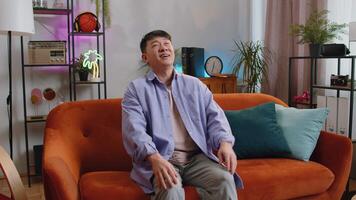 Tired asian man enjoy relaxing on home sofa resting napping after hard working day, closed his eyes video