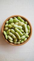 Green beans in a bowl on a white table photo