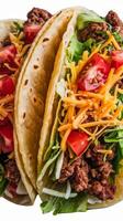 Three tacos with meat, lettuce and cheese photo