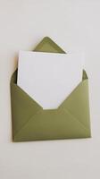 An open green envelope with a blank card inside photo