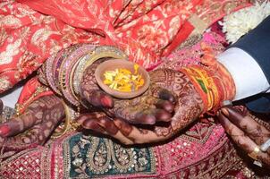 A man and woman are holding hands with their hands decorated with henna photo