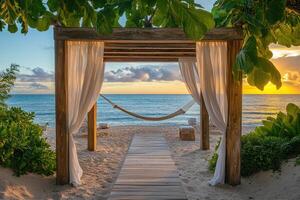 Hammock under a canopy overlooking tropical beach at sunrise photo