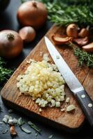 Chef chopping onions on wooden cutting board with herbs and garlic photo