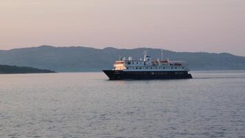 Aerial front tracking view of a generic cruise ship saling over the ocean during sunset time video
