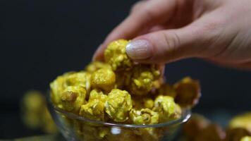 caramel popcorn Macro view how woman's hand takes popcorn. Caramel popcorns in the bowl. Probe lens. video