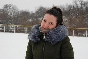 Winter portrait of a woman in a fur-trimmed jacket against a snowy landscape photo