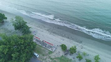 Aerial View of Tinangon Beach with Waves, Sand, and Visitors Enjoying the Shoreline video
