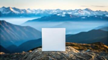 Blank paper on top of mountain with mountains in background photo