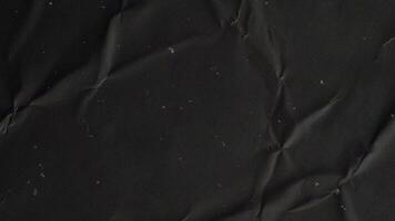 black crumpled wrinkled sheet of paper background texture. Stop motion animation. video