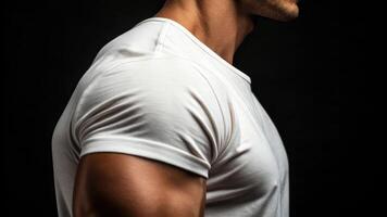A man in a white t - shirt standing in front of a black background photo