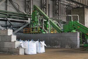 Green recycling plant with conveyor belts. Industrial facility with green machinery. Modern center with waste sorting automated systems. Eco-friendly factory waste management and recycling facility photo