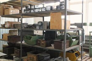 Recycled industrial storage containers on metal shelves. Used plastic and metal bins on racks. Containers for recycling and storage. Storage of recycled materials in box. Sustainable waste management photo
