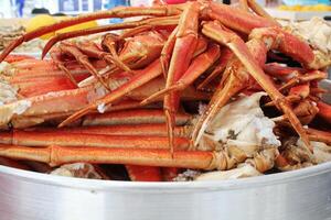 Appetizing cooked crab legs and claws, fresh seafood delicacy. Ready to eat, presented on a platter. Close-up, food photography photo