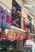 Colorful market stall with dresses, bags, and souvenirs for sale. Tourist destination shopping with vibrant textiles and handcrafted goods photo