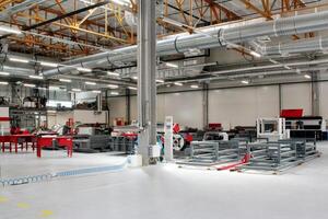 Industrial facility with high ceilings, visible piping and machinery. Manufacturing plant with modern technology and infrastructure. Space of factory, exposed pipes, various warehouse equipment photo