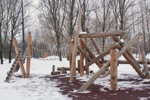 Eco-Friendly Wooden Playground in Winter Landscape. Sustainable Timber Play Structure in Snowy Park. Environmentally Renewable Resource Playground with Natural Wood. Eco-Designed Area in Cold Climate photo