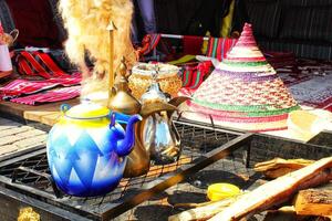Colorful display of traditional Arabic items, including a teapot, woven cone, and fabrics. Souvenirs or market goods showcasing Middle Eastern culture and craftsmanship. photo
