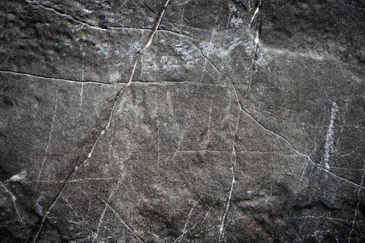 Textured Dark Stone Surface with Natural Cracks and Patterns for Background or Design Elements photo