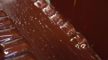 Candies come out from the flow of chocolate. Sweets deepened in a thick layer of chocolate. Close up. video