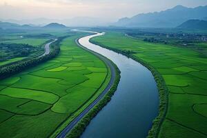 Winding river flowing through green rice fields and mountains in Asia photo