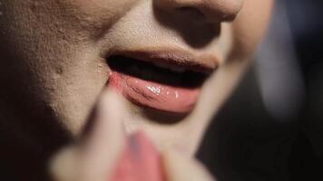 Close-up shot of a woman applying a lip gloss with brush for lips, showcasing beauty and makeup routine, glamour and personal care. video