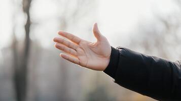 Hand reaching out in a natural setting during a sunny day, symbolizing connection and invitation. photo