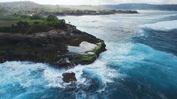 Waves crashing on the rocks, drone view of Devil's rock with blue ocean on Nusa Lembongan island video