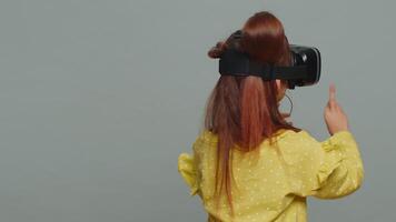 Child kid girl using headset helmet app to play simulation game, watching virtual reality 3D video