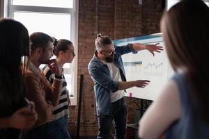 In a sleek glass office space, a team of business professionals engage in lively discussions and exchange strategic ideas, showcasing collaboration and innovation at the heart of modern corporate photo