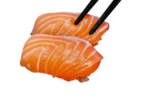 Top view of Japanese fresh salmon sushi with Japanese rice and chopsticks, focus selective photo