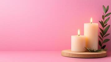 Serene Candle Arrangement with Green Foliage on Pink Background photo