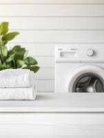 Fresh towels on a white surface, near a washing machine. photo