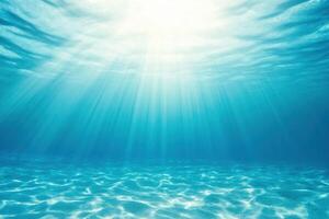 Underwater Sunlight, Light rays penetrate the clear blue ocean, illuminating the sandy sea floor photo