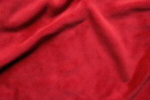 Red fabric with soft texture and gentle folds, creating a warm and inviting abstract pattern photo
