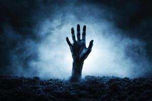A ghoulish hand reaches upward from a dark, earthy grave against a backdrop of eerie fog photo