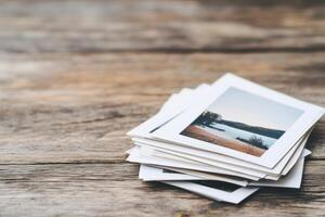 Stack of printed photos of scenic landscapes, evoking memories, stories, and nostalgia