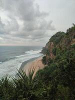 a view of the beach from a cliff overlooking the ocean photo