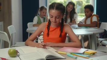 Caucasian girl student primary class school education smiling child kid daughter pupil schoolgirl in library studying learning prepare lesson task writing exam books reading happy looking at camera video