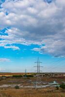 High-voltage lines on steel structures with wires against the background of the sky with clouds. photo