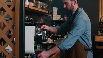 Caucasian waiter staff man guy employee making drink latte in cafe worker adding milk foam in cappuccino cafeteria barista using coffee machine catering small business male in apron serving customer video