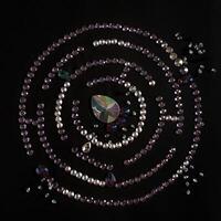 Rhinestones in the form of a labyrinth with a flat lay, isolated on a black background. Top view pattern or labyrinth of rhinestones in lilac and silver color. photo