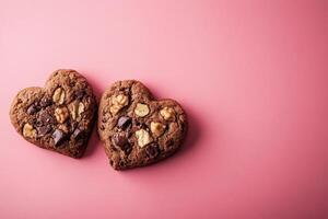 Heart-shaped chocolate walnut cookies on pink background photo