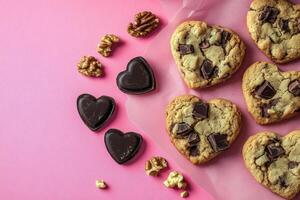 Heart-shaped cookies and chocolate hearts on pink background with walnuts photo